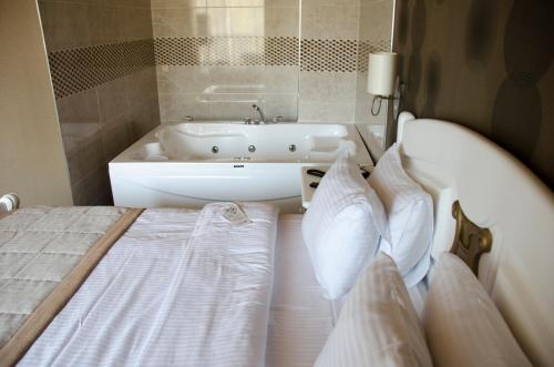 Sputnik Hotel Batumi في باتومي: غرفة نوم مع سرير وحوض استحمام