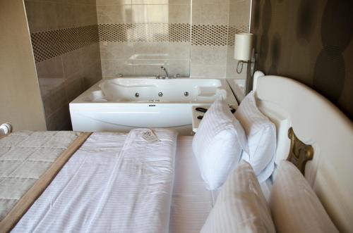 a bedroom with a bed and a bath tub at Sputnik Hotel Batumi in Batumi