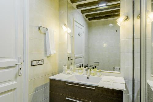 a white bathroom with a sink and a mirror at Oriente Palace Apartments in Madrid