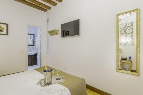 a white room with a table and a mirror at Oriente Palace Apartments in Madrid