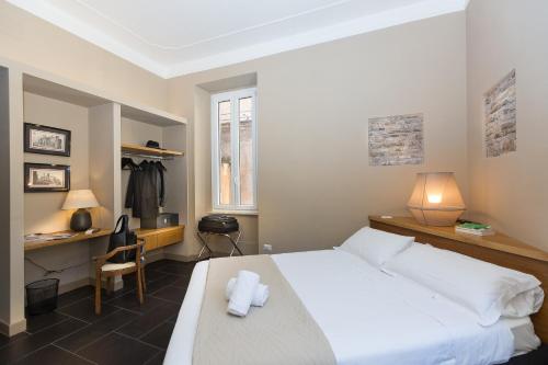 una camera con letto bianco, scrivania e sedia di App Condotti Luxury Apartment In Rome a Roma