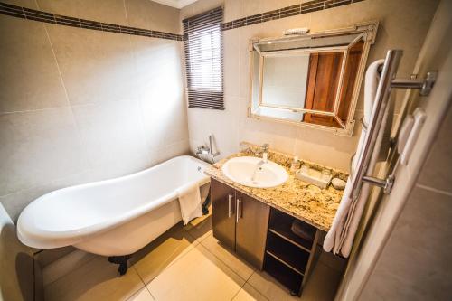 a bathroom with a bath tub and a sink at AnnVilla Guesthouse in Klerksdorp
