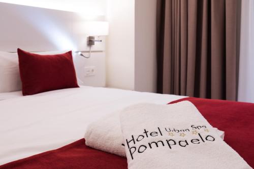 a hotel room with a bed with a towel on it at Hotel Pompaelo Plaza del Ayuntamiento & Spa in Pamplona