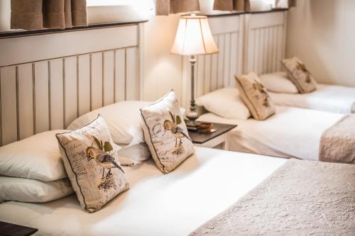 a bedroom with two beds with pillows and a lamp at AnnVilla Guesthouse in Klerksdorp