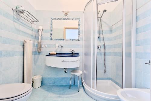 a blue and white bathroom with a sink and a shower at Hotel Aurora & Appartamenti in Nago-Torbole
