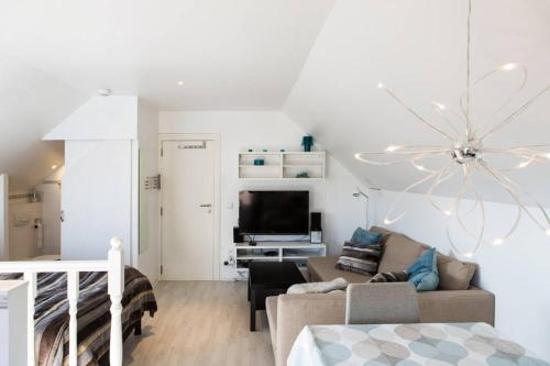 ラ・ウルプにあるStudio Apartment Albaのソファとテレビのある白いリビングルーム
