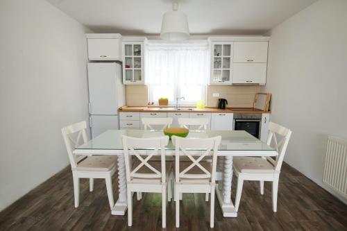 a white kitchen with a table and chairs at The Green Apartments in Magarevo