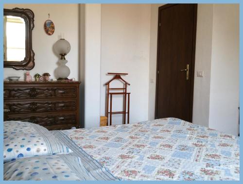 a bedroom with a bed and a dresser and a window at Notte di Luna room & breakfast in Oristano