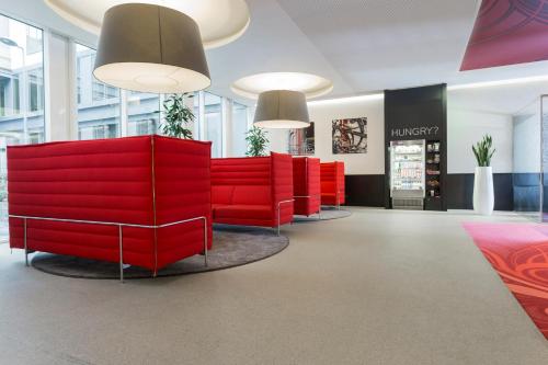 a waiting room with red chairs in a store at Hotel Park Inn by Radisson Brussels Midi in Brussels