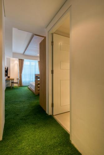 an open door in a room with green carpet at Yan's House Hotel in Kuta