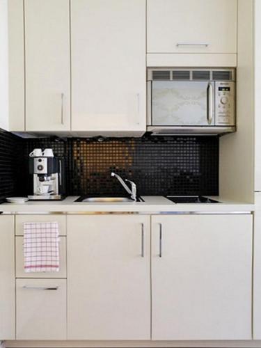 a kitchen with white cabinets and a sink and a microwave at VISIONAPARTMENTS Rue Caroline - contactless check-in in Lausanne