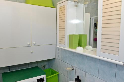 a kitchen with white cabinets and a green microwave at Apartment Juras in Opatija