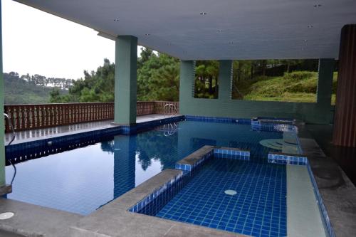 a large swimming pool with blue tiles on the floor at Crosswinds Nature View Suite in Tagaytay