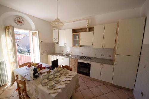 uma cozinha com armários brancos e uma mesa com comida em Bed & Breakfast Porta Santi em Cesena