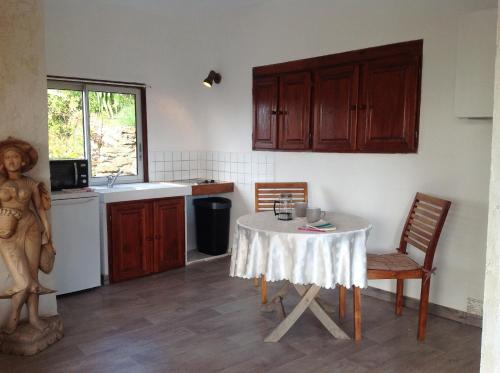 une cuisine avec une table et des chaises dans une pièce dans l'établissement La Coccinelle, sur l'Île du Levant