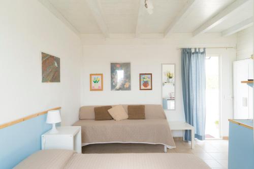 アグリジェントにあるLa Terrazza di Agrigentoの白いベッドルーム(ベッド2台、窓付)