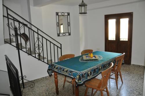 a dining room with a table and chairs and a staircase at Casa Tamayo in Órgiva
