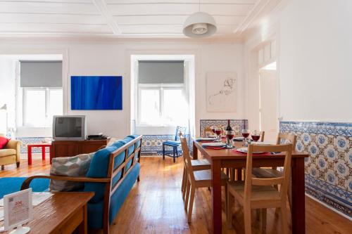 uma sala de estar com uma mesa e uma sala de jantar em ALTIDO Classic 3BR home with workspace in Chiado, 2mins from Baixa-Chiado subway em Lisboa