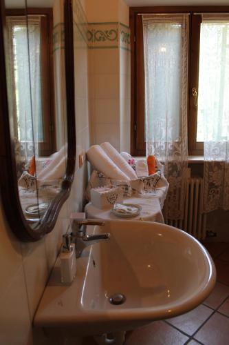 W łazience znajduje się umywalka, lustro i ręczniki. w obiekcie Agriturismo alle Torricelle w Weronie