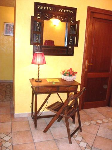 ローマにあるMax Houseのランプと椅子と鏡のあるテーブル