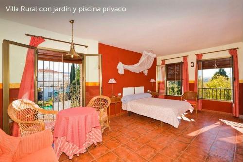 een slaapkamer met een bed en een tafel en stoelen bij Villa Loma Linda in Ogíjares