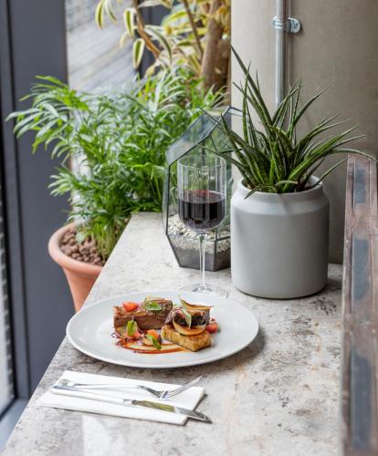a plate of food and a glass of wine on a table at Leman Locke in London