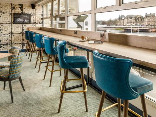 a row of blue chairs at a bar at Mercure Inverness Hotel in Inverness