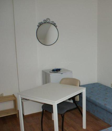 a white table and chairs in a room with a mirror at Vila Ria in Bratislava