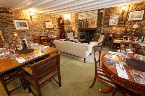 uma sala de estar com mesas e cadeiras e um sofá em Rams Head Inn em Dolton
