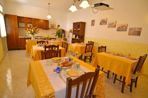 モルチャーノ・ディ・レウカにあるLe Fate del Salentoのダイニングルーム(テーブル、椅子、黄色のテーブルクロス付)