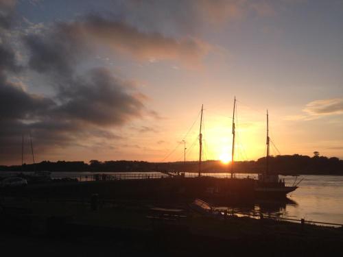 a boat docked in a harbor with the sun setting at Apartment 2 The Waterfront in Portaferry