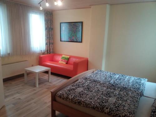 a bedroom with a red couch and a red chair at Steeger Weinstube in Bacharach