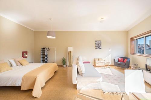 a bedroom with a large bed and a living room at BmyGuest - Santa Catarina Light Apartment in Porto