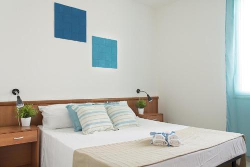 una camera da letto con un letto e due asciugamani di Residence La Poesia - Direzione Salento a Torre dell'Orso