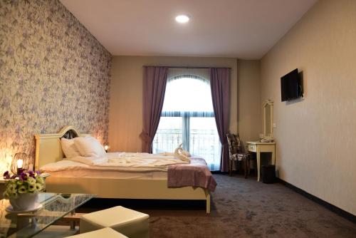 スヴィレングラッドにあるHesteya Hotelのベッドルーム1室(ベッド1台、大きな窓付)