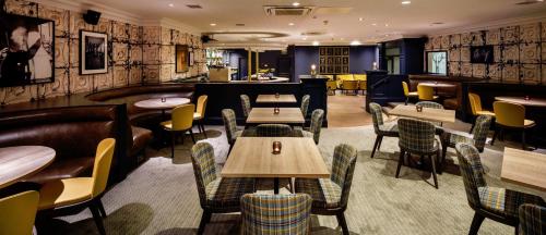 a restaurant with tables and chairs and a bar at Mercure Inverness Hotel in Inverness
