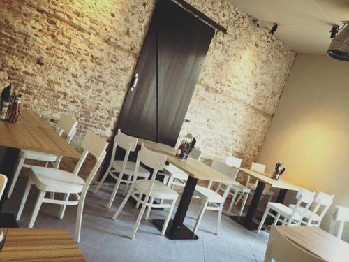 ein Restaurant mit Tischen und Stühlen und einer Ziegelwand in der Unterkunft Studio's de Domburger in Domburg