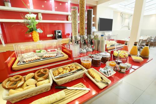 a buffet with bread and other food on a counter at Le Grand H&ocirc;tel de Normandie in Paris
