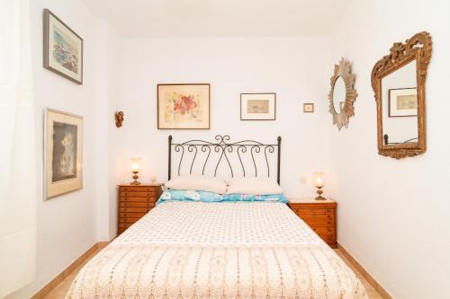 sypialnia z łóżkiem i lustrem na ścianie w obiekcie Carabeillo 13 Apartments Casasol w mieście Nerja