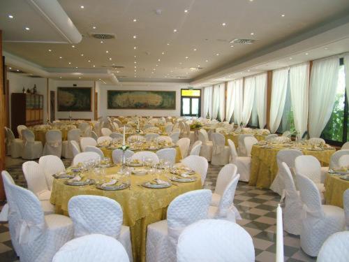 a large banquet hall with tables and white chairs at Platani Hotel in Bolsena