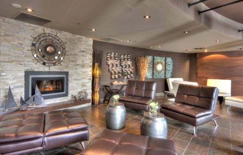 a living room with leather furniture and a fireplace at The Lonsdale Quay Hotel in North Vancouver