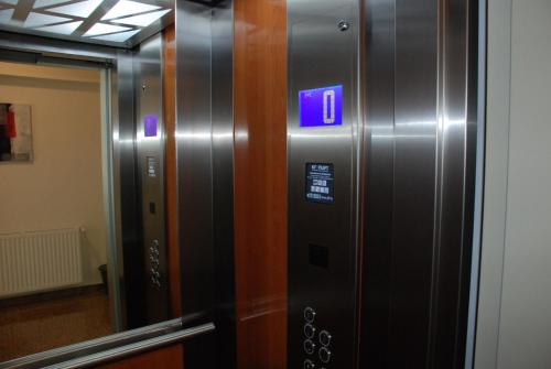 a elevator with a blue sign on the side of it at Victoriei City Studios in Bucharest