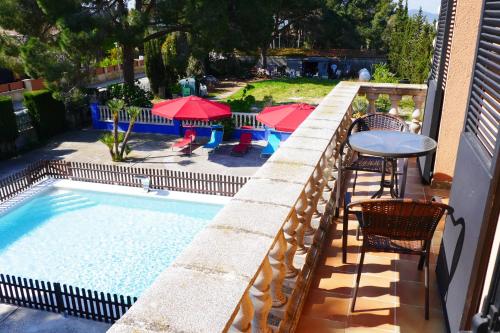 a swimming pool with a table and chairs and umbrellas at Hotel Restaurant El Bosc in Banyeres del Penedes