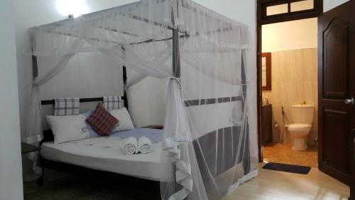 a bedroom with a bed with a canopy at River Side Homestay Apartment in Kandy