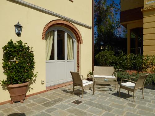 a patio with two chairs and a white door at Casa Vacanze Villa Cerine in Altopascio