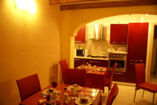comedor con mesa y cocina en Sa Mamma e Sole B&B, en Cala Gonone