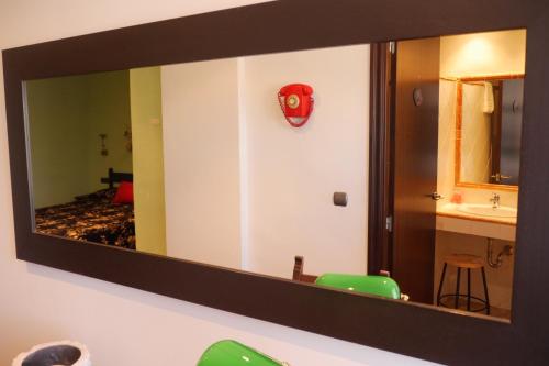 a mirror hanging on a wall in a bathroom at Hotel Restaurant El Bosc in Banyeres del Penedes