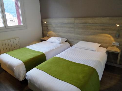 two beds sitting next to each other in a room at Jura Hotel Restaurant Le Panoramic in Saint-Claude