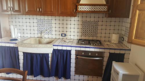 uma cozinha com um lavatório e um fogão em Vecchio Baglio Cofano em Custonaci