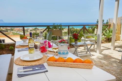 a table with food and drinks and oranges on a balcony at Appartaville Castellammare del Golfo in Castellammare del Golfo